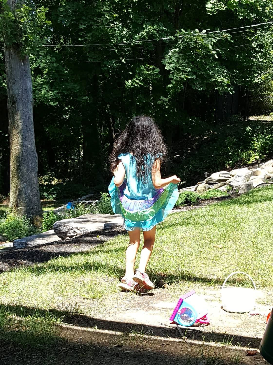 Little one holding dress and skipping.